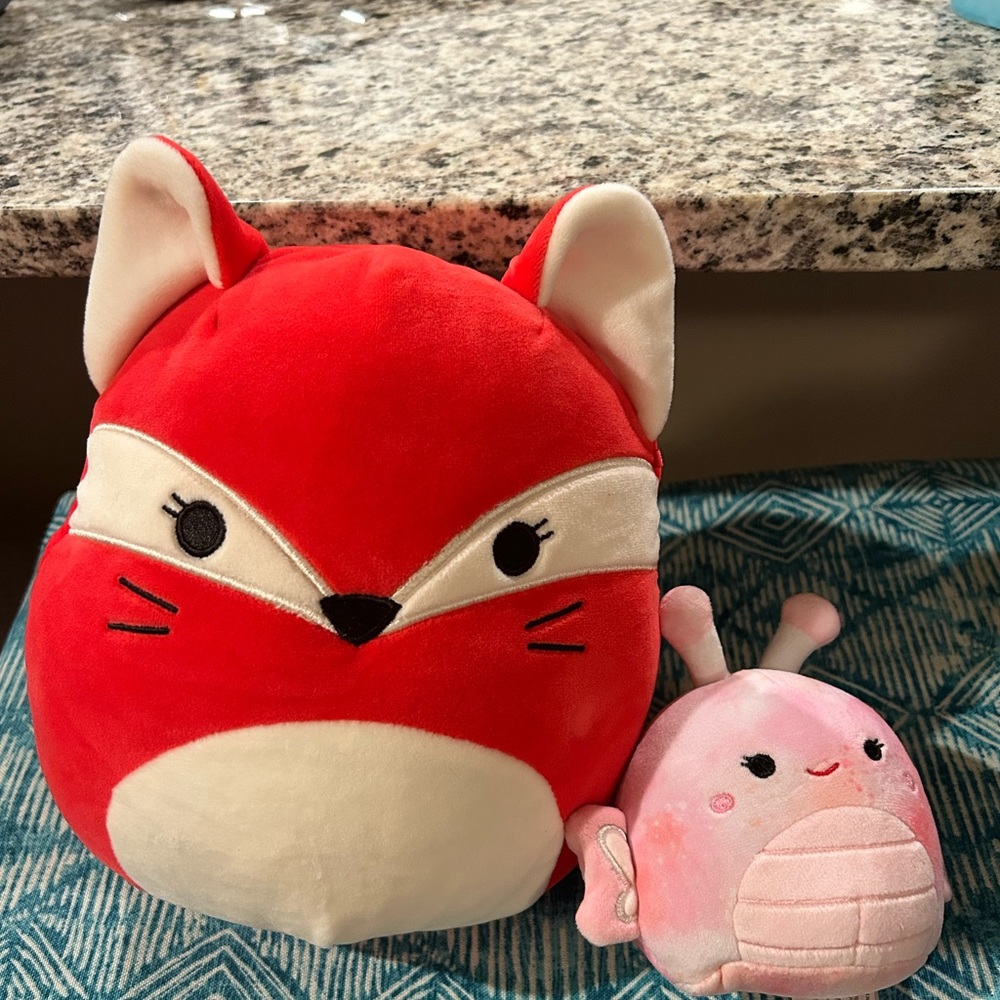 Two squishmallows a mini butterfly and fifi the fox